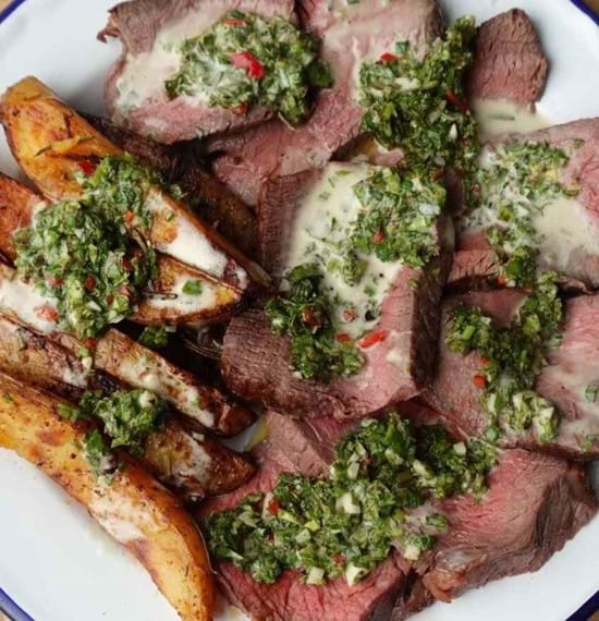 Xavier's Top Beef Rump Joint paired with a fresh chimichurri and bearnaise sauce A plate of sliced beef top rump served with chips and chimichurri and bearnaise sauce generously applied